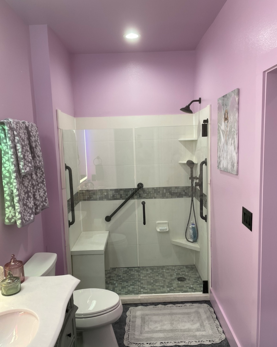 Custom walk-in shower with grab bars and mosaic tile floor
