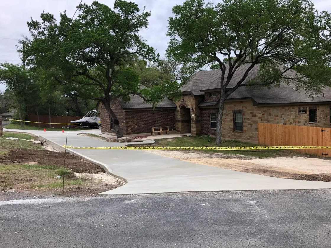 Freshly finished curved driveway in front of a brick and stone home