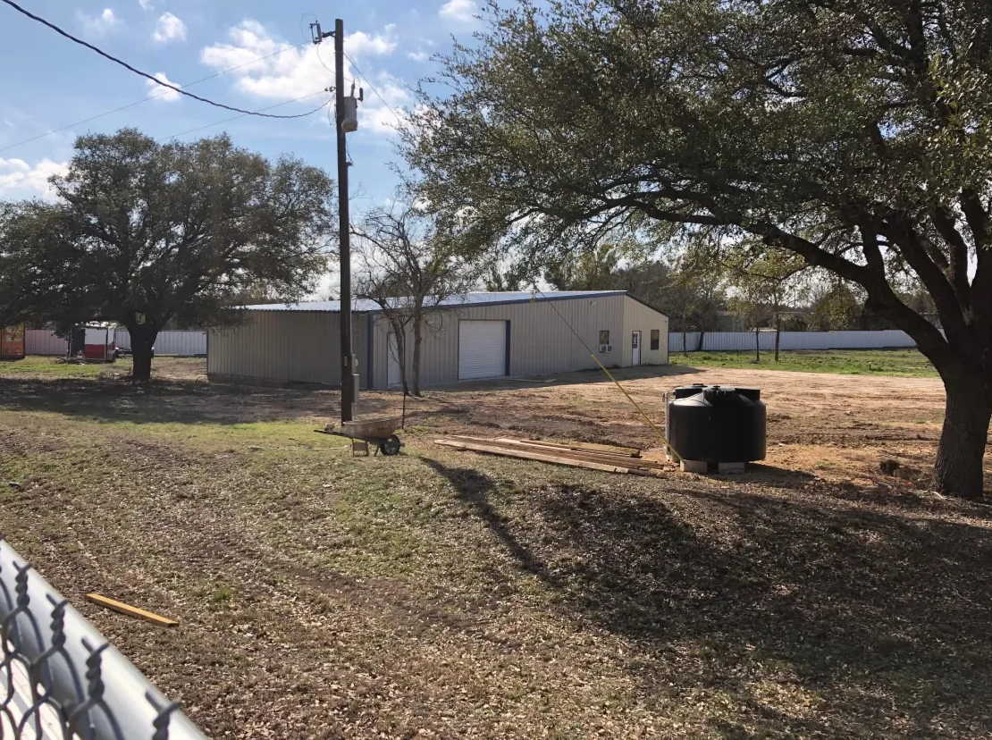 Wide view of a completed metal shop structure on site