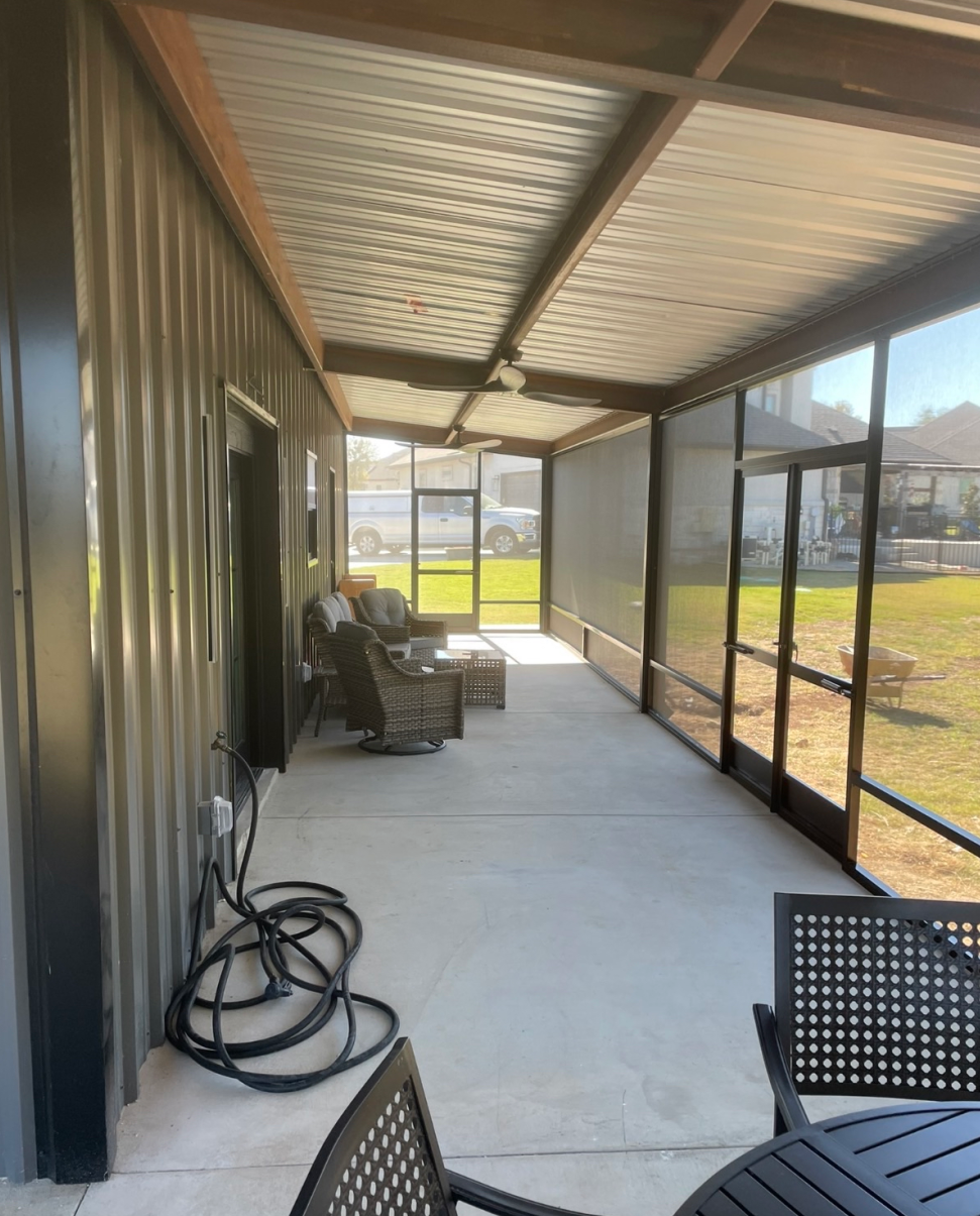 Screened-in concrete porch with metal roof and ceiling fan