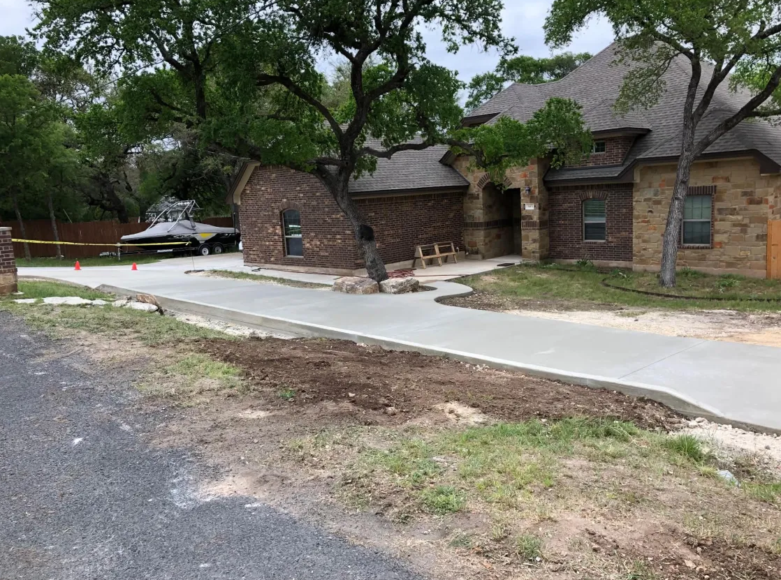 Side view of a new concrete driveway wrapping around a home