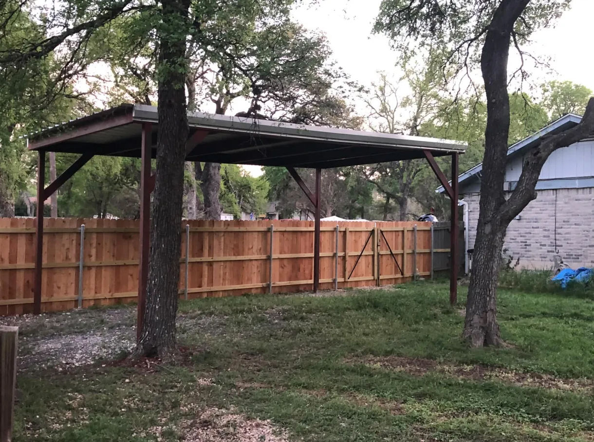 Backyard carport on concrete pad with cedar fence
